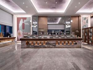 a restaurant with a counter in the middle of a room at Mercure Chengdu Shuangliu in Chengdu