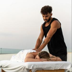 a man helping a woman on a bed at Forest Calm Faliraki in Faliraki