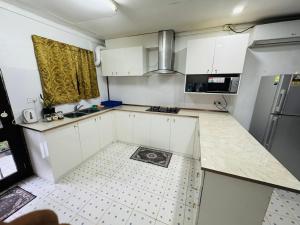 a kitchen with white cabinets and a tile floor at Three bedroom apartment in Suva +5 photos