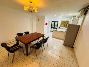 a kitchen with a table and chairs and a refrigerator at Three bedroom apartment in Suva