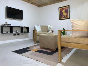 a living room with a couch and a tv on the wall at Almonte House in Puerto Plata