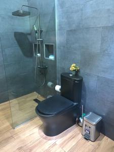 a bathroom with a black toilet and a shower at Almonte House in Puerto Plata