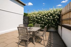 a table and chairs on a patio with a hedge at The Millstone in Buncrana