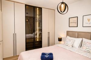 a bedroom with a king sized bed and a closet at VIP Apartman Friendly Home in Tuzla