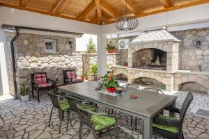 a patio with a table and a stone fireplace at Apartments Baretić in Crikvenica
