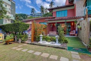 a house with a garden in front of it at Pousada Praia Bela in Ilhéus