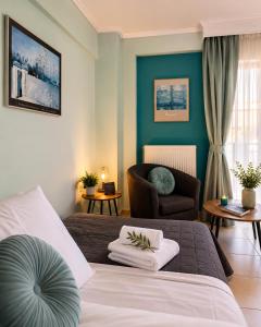 a hotel room with a bed and a chair at Odyssey Mare Steps from the Sea in Perea