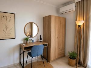 a room with a desk and a mirror and a chair at Odyssey Mare Steps from the Sea in Perea