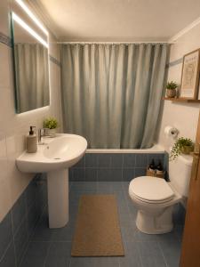 a bathroom with a sink and a toilet and a shower at Odyssey Mare Steps from the Sea in Perea