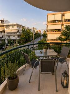 a patio with a table and chairs on a balcony at Odyssey Mare Steps from the Sea in Perea