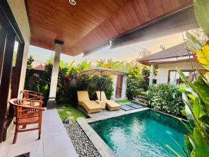a backyard with a swimming pool and a house at pondok ubud nia cahya in Tegalalang