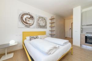 a bedroom with a white bed and a kitchen at Baldo View Studio in Toscolano Maderno +24 photos