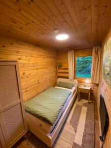 a small room with a bed in a log cabin at Gemütliche Hütte im Grünen in Dammbach