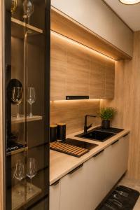 a kitchen with a sink and a counter with wine glasses at VIP Apartman Friendly Home in Tuzla
