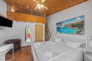 a bedroom with two beds and a tv and a staircase at Gästehaus Parkblick in Rust