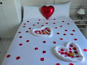 a bed with heart shaped pillows on it at Residencial New Stilo-Falésia in Canoa Quebrada