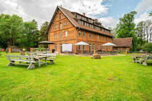 ein großes Gebäude mit Picknicktischen davor in der Unterkunft Weizenkammer in Rechlin
