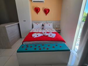 a bedroom with a bed with two hearts on the wall at Residencial New Stilo-Falésia in Canoa Quebrada
