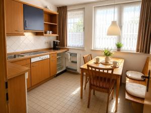 a kitchen with a table and a dining room at Glaeßer Appartements in Burg auf Fehmarn