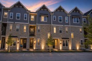 an apartment building at dusk with lights on at Collin Creek Executive Residence in Plano