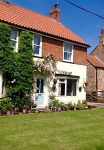 a large brick house with a green yard at The Cherries in York