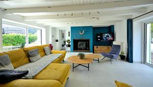 a living room with a yellow couch and a table at Le Nid de Mazerolles in Sucé