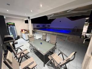 a pool room with a table and chairs and a swimming pool at Villa Mešić in Stojčevac