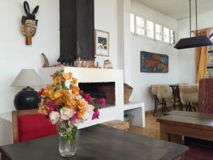 a vase of flowers on a table in a living room at Auberge De La Plage in Sidi Kaouki