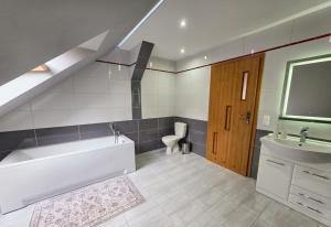 a bathroom with a tub and a sink and a toilet at Siedlisko Drwęck in Drwęck +56 photos