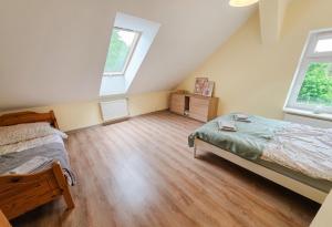 a attic bedroom with a bed and two windows at Siedlisko Drwęck in Drwęck