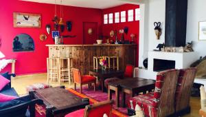 a living room with red walls and a table and chairs at Auberge De La Plage in Sidi Kaouki