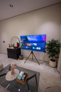 a living room with a large flat screen tv on a wall at استديو خاص in Al Khobar +6 photos