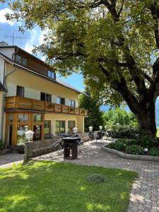 a house with a tree in front of it at Pension ALPENHAUS in Vorderstoder