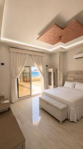 a bedroom with a large bed and a large window at Nuweiba house camp in Nuweiba