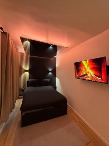 a bedroom with a bed and a tv on the wall at Appartement jacuzzi d'exception - proche Paris in Drancy