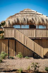 a building with a thatch roof and a staircase at Bali Andino Vilas in Ciudad Lujan de Cuyo