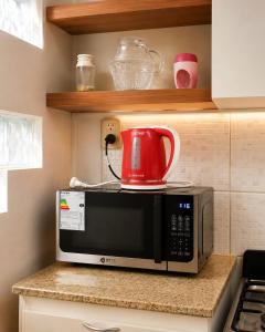 a red tea kettle on top of a microwave at Caelum House Apartamento Con cochera in Rafaela