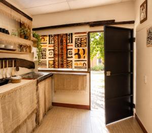 a kitchen with a black door and a window at Casa Xuchi in Juayúa