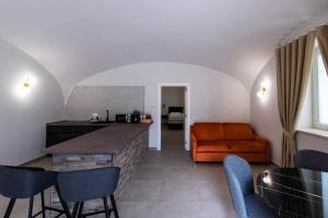 eine Küche und ein Wohnzimmer mit einer orangefarbenen Couch in der Unterkunft Dimora Rosae in Telese