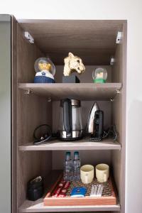 a cupboard with a coffee maker and other kitchen items at استديو خاص in Al Khobar