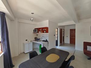 a living room with a table and a kitchen at Casa Hormiga in Panajachel