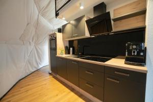 a kitchen with brown cabinets and a stove top oven at Glamping-Steiermark in Pöllauberg