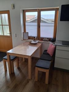 a kitchen with a wooden table and chairs and a window at Ferienwohnung Schneckenpointner in Waging am See +6 photos