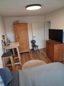 a living room with a bed and a television and a table at Ferienwohnung Schneckenpointner in Waging am See