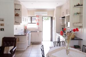a kitchen with a table with a vase of flowers on it at Sole's Leap in Scottburgh