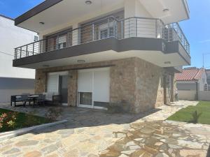 a house with a balcony and a patio at Diana House in Nikiti