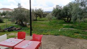 a picnic table and red chairs in a field at Casita del Romero Ronda in Ronda