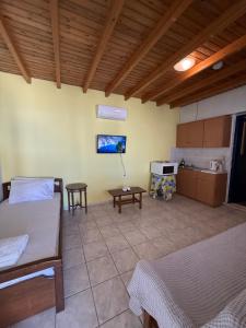 a room with two beds and a table in it at Yellow Beach House in Logaras