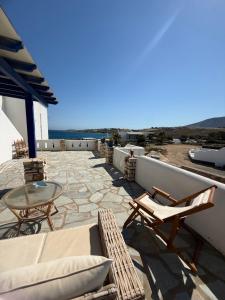 a patio with chairs and a table on a roof at Coral Nest in Logaras