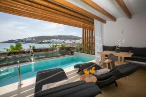 a living room with a swimming pool and a table at Thalassa boutique hotel-Adults only in Platis Gialos